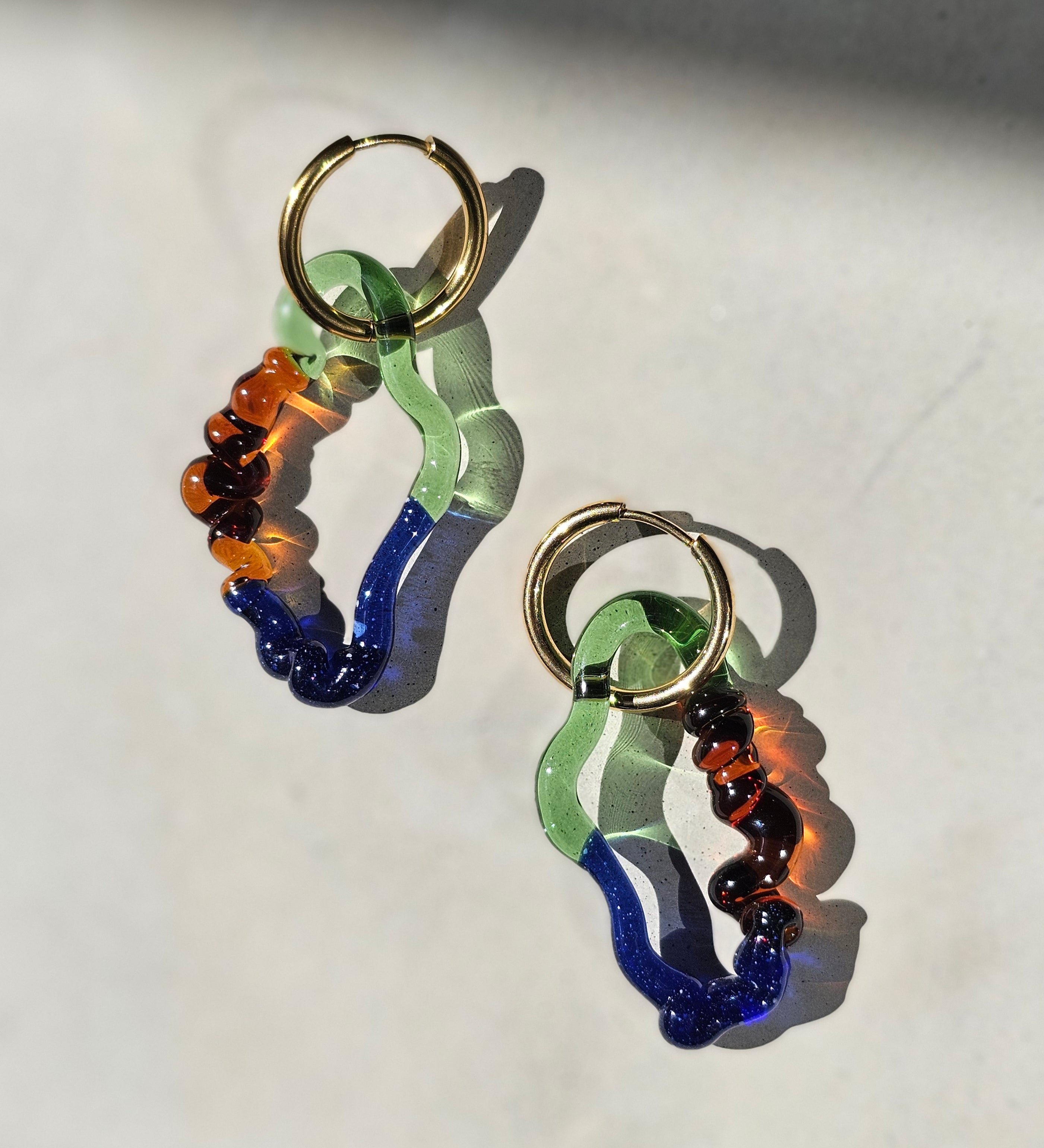 Handgefertigte Drift Hoops aus Borosilikatglas in Blau, Grün und Amber mit goldfarbenen Edelstahlcreolen kitsch kiosk
